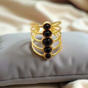 Anillo en acero dorado con piedras negras